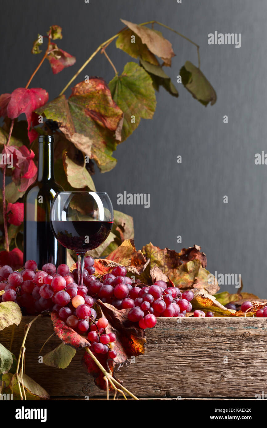 Red wine and grape with vine leaves on a old wooden table.Copy space ...