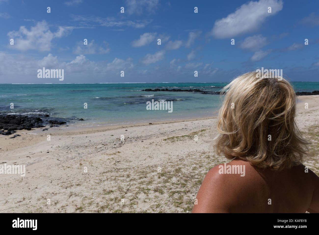 Blonde woman looking at the sea in Mauritius Stock Photo