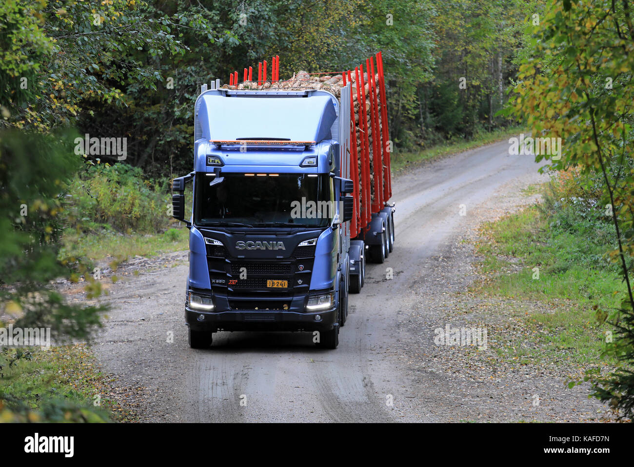 LAUKAA, FINLAND - SEPTEMBER 22, 2017: Scania R650 XT logging truck is ready to take on a hill on a narrow forest road during Scania Laukaa Tupaswilla  Stock Photo