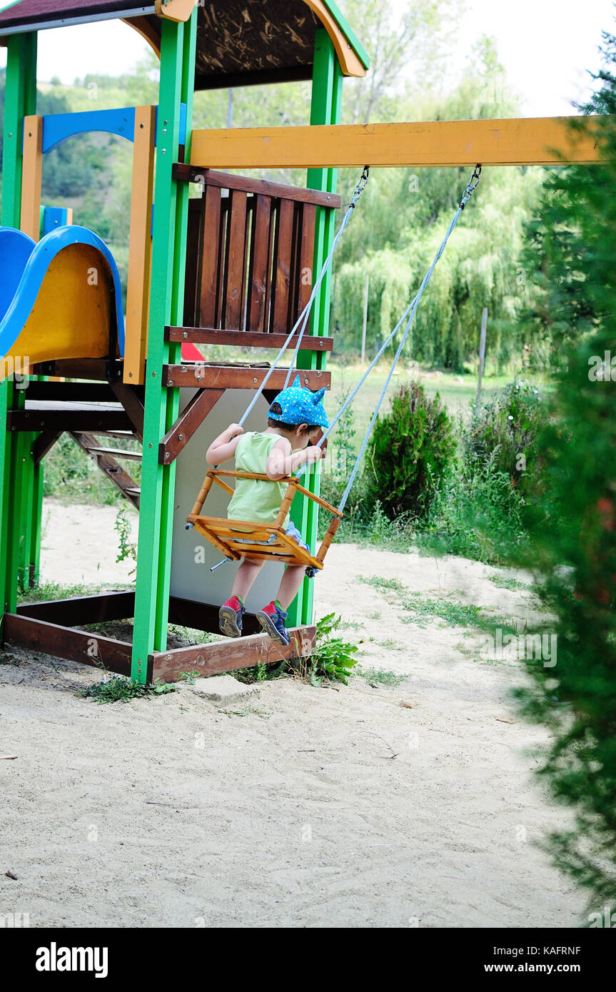 Little boy on a swing on a hot summer day Stock Photo