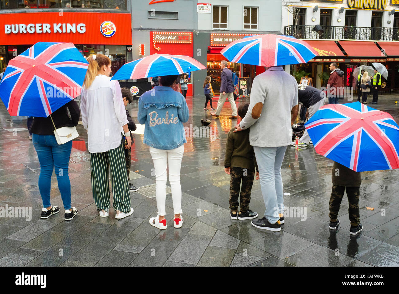 Tourists with Union Jack umbrellas, Leicester Square, London, UK Stock Photo