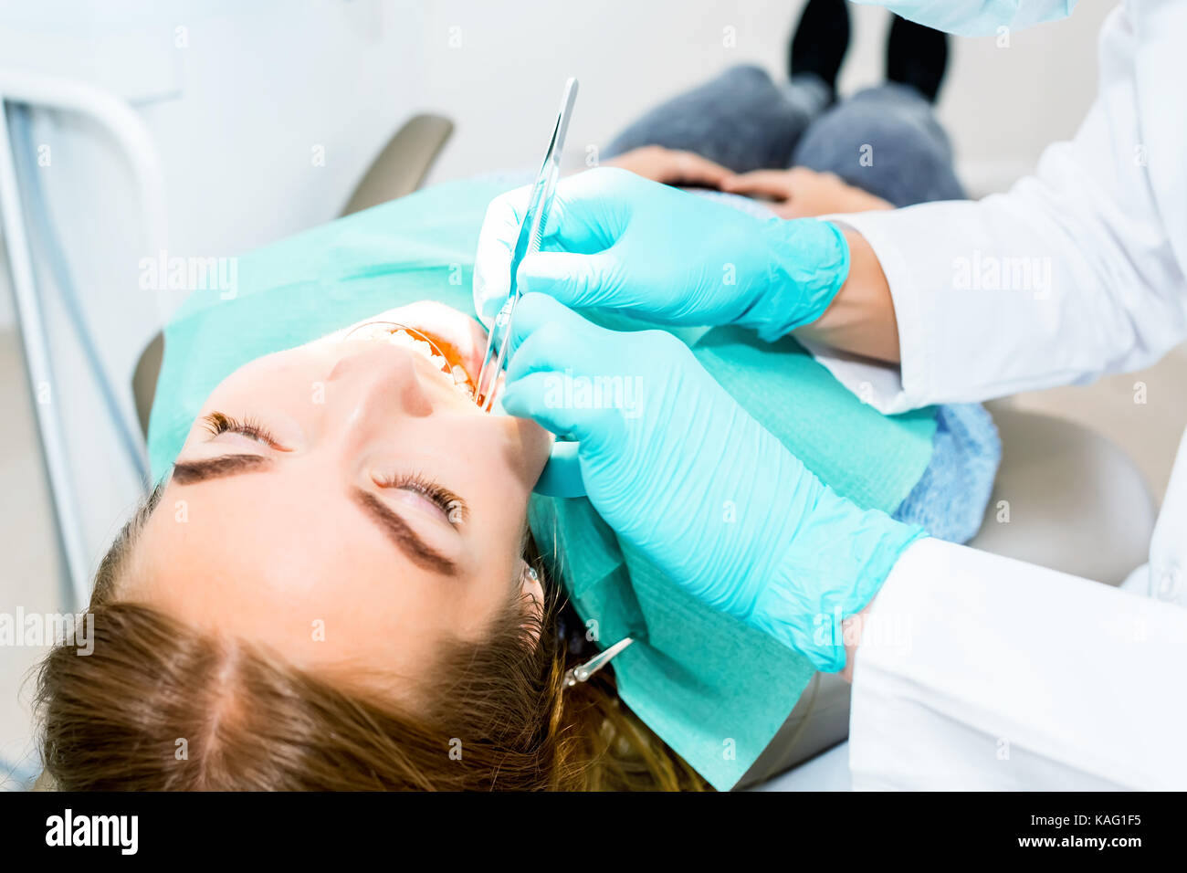 Female dentist checking up patient teeth with braces at dental clinic