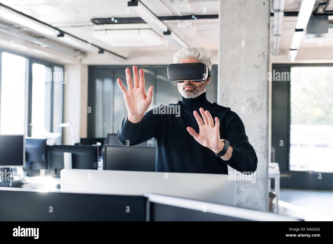 Mature businessman with VD goggles in the office Stock Photo - Alamy
