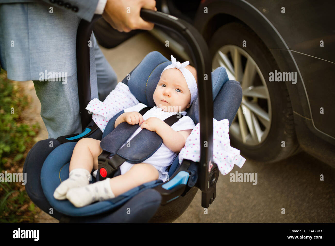 Unrecognizable man carrying his baby girl in a car seat. Stock Photo