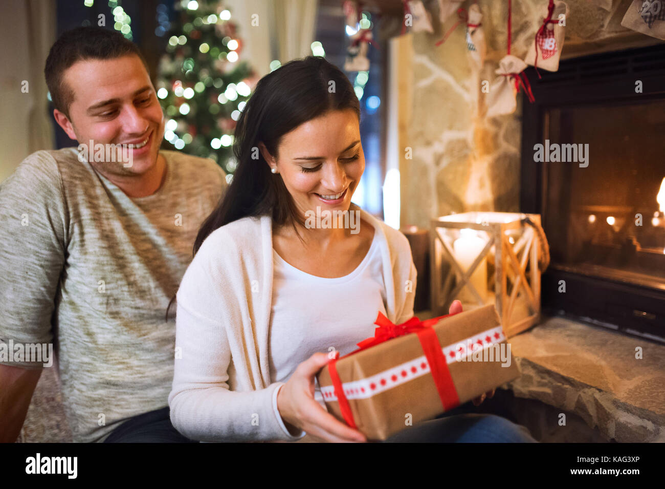 Couple in front of fireplace. Christmas time. Stock Photo