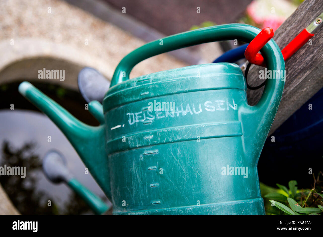 A watering can hangs on a post in the graveyard at St Stephan's Church