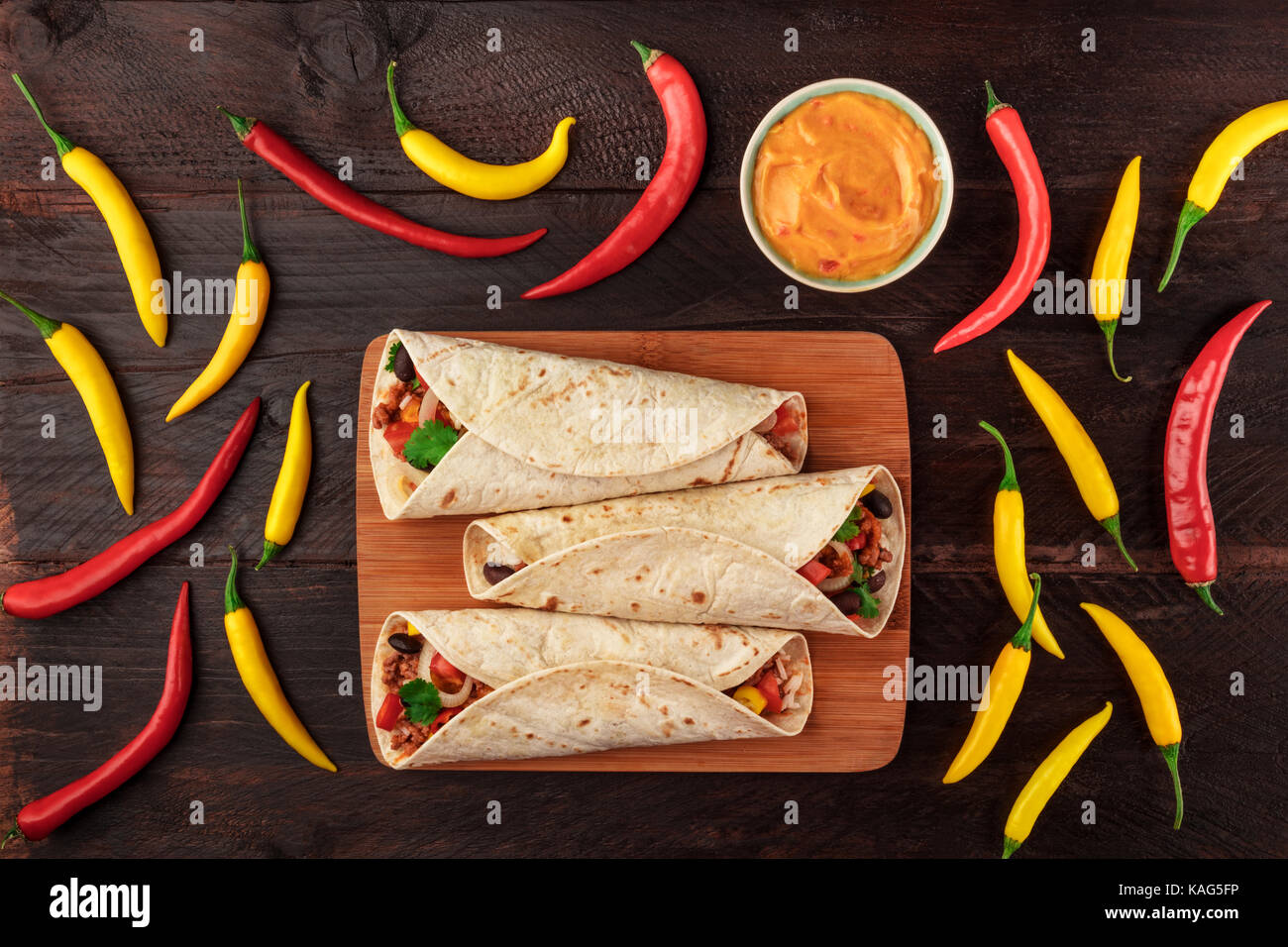 Mexican burritos with cheese salsa, and chili peppers Stock Photo Alamy