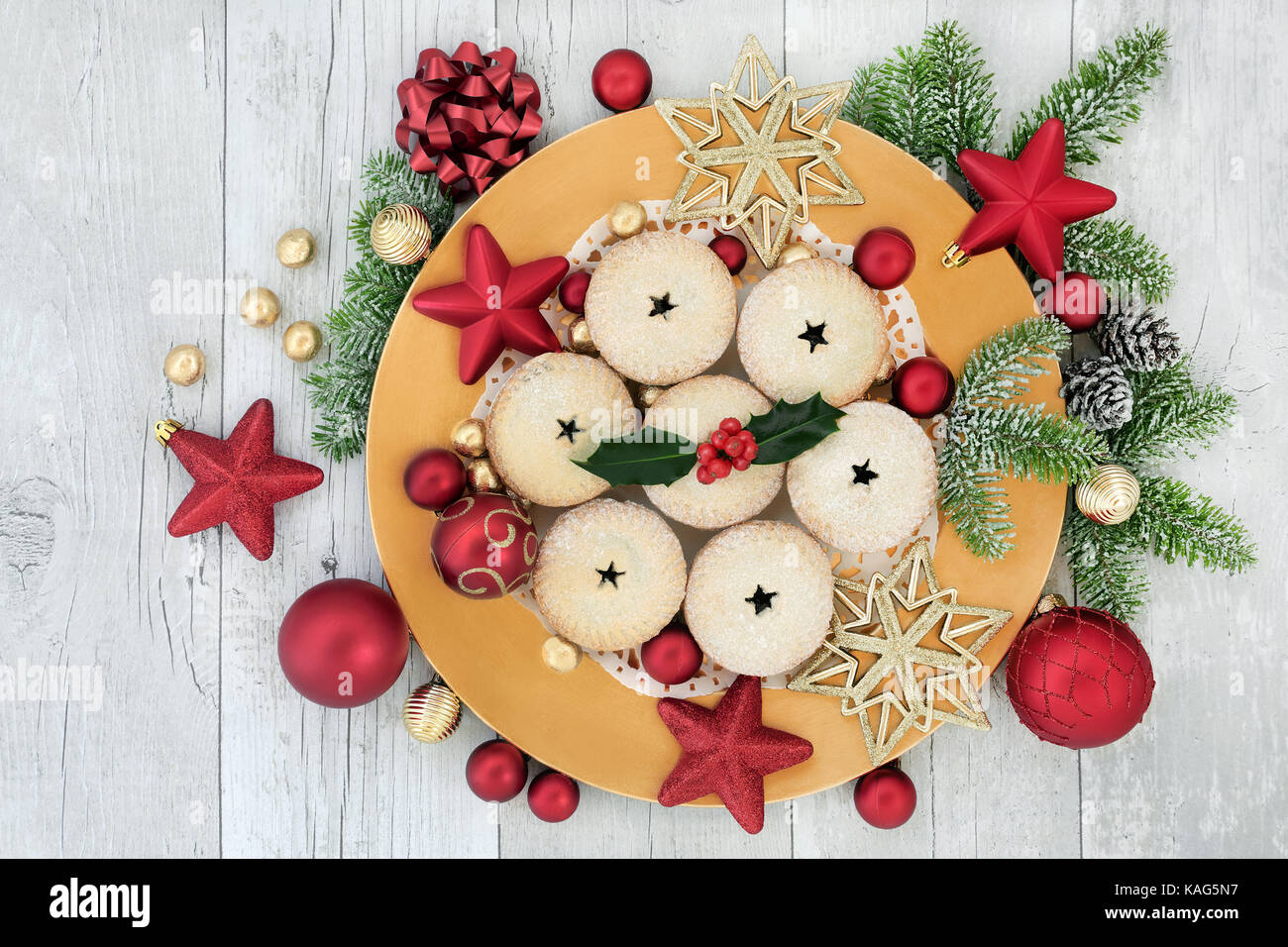 Homemade christmas mince pies on a gold plate with red and gold bauble ...