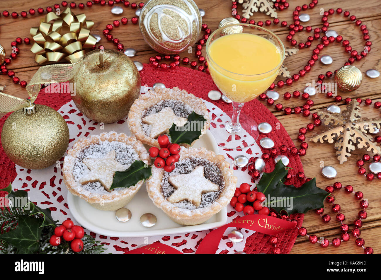 Christmas mince pies tarts with holly on a heart shaped plate with egg ...
