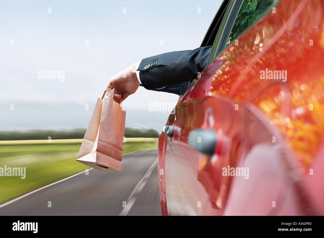 Closeup Of A Person's Hand Throwing Trash Out Of Car Window Stock