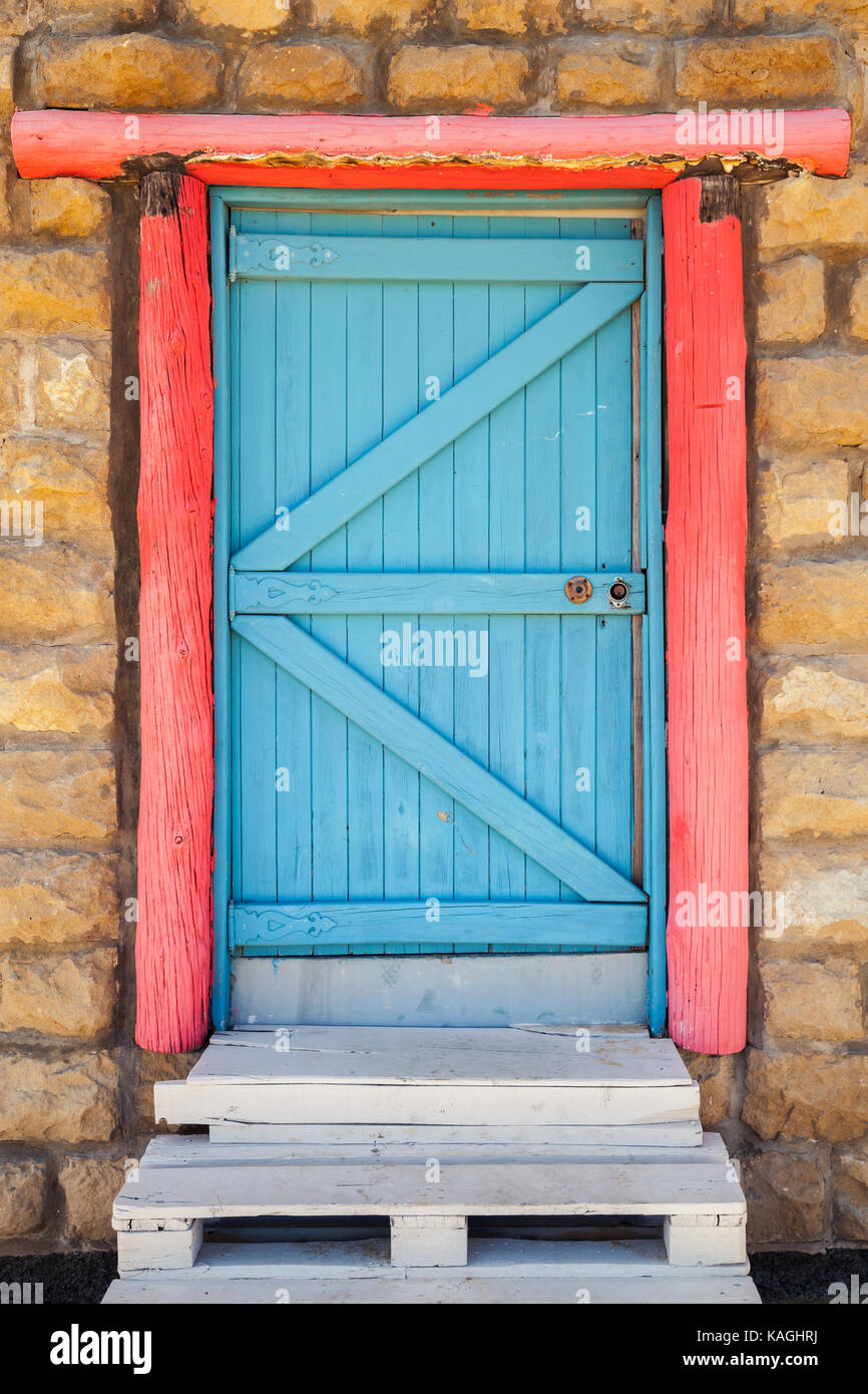 Blue wooden door with red frame in old stone wall, background photo texture  Stock Photo - Alamy