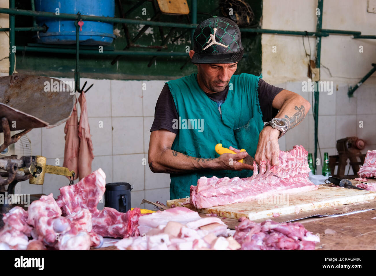 Havana, Cuba  A Cuban butcher works on a piece of meat in a market in Centro Habana, Havana, Cuba. Stock Photo