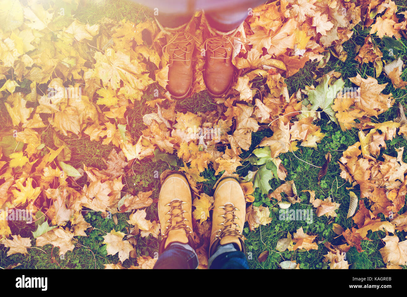 couple of feet in boots and autumn leaves Stock Photo Alamy