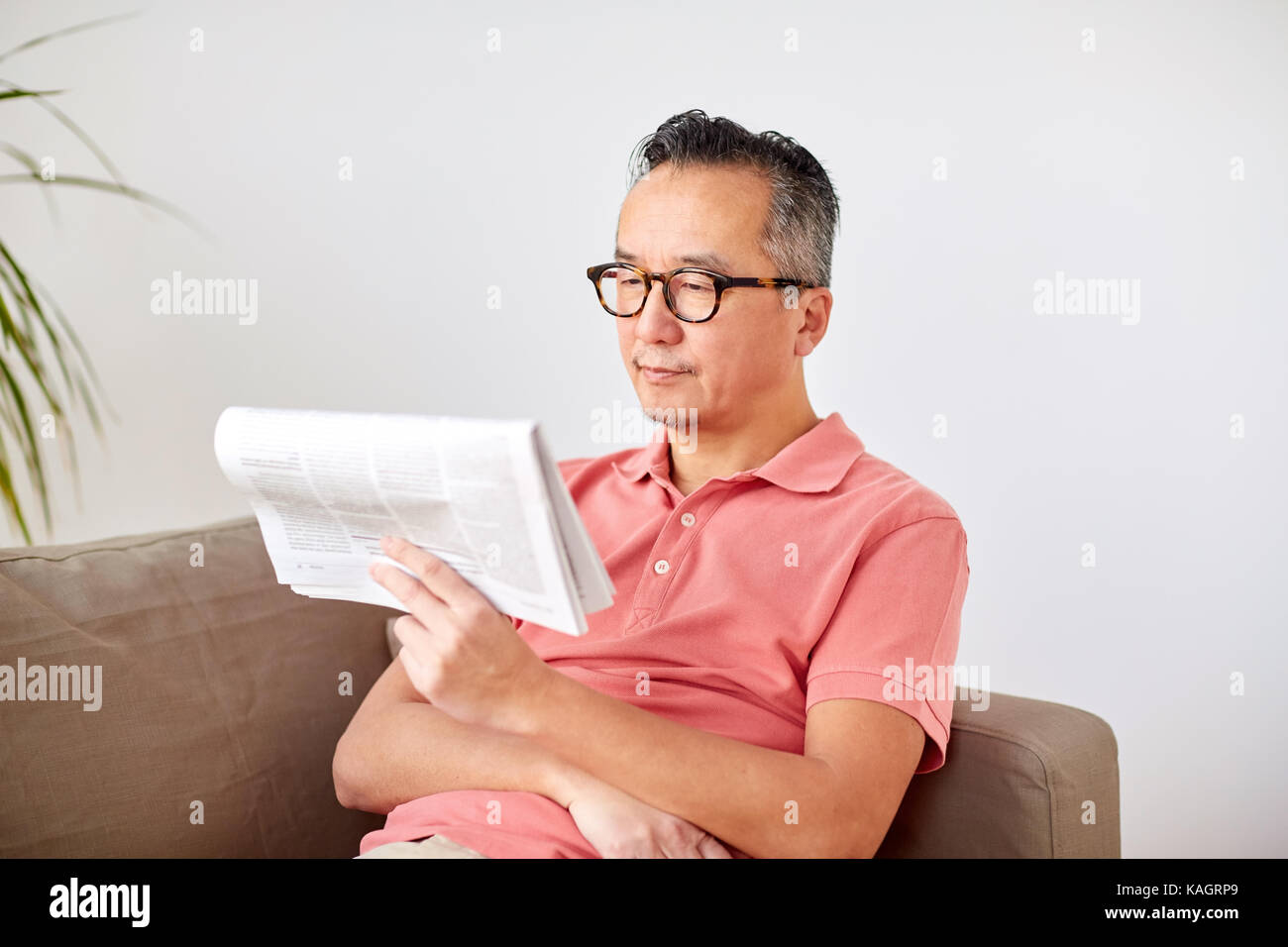 happy man in glasses reading newspaper at home Stock Photo