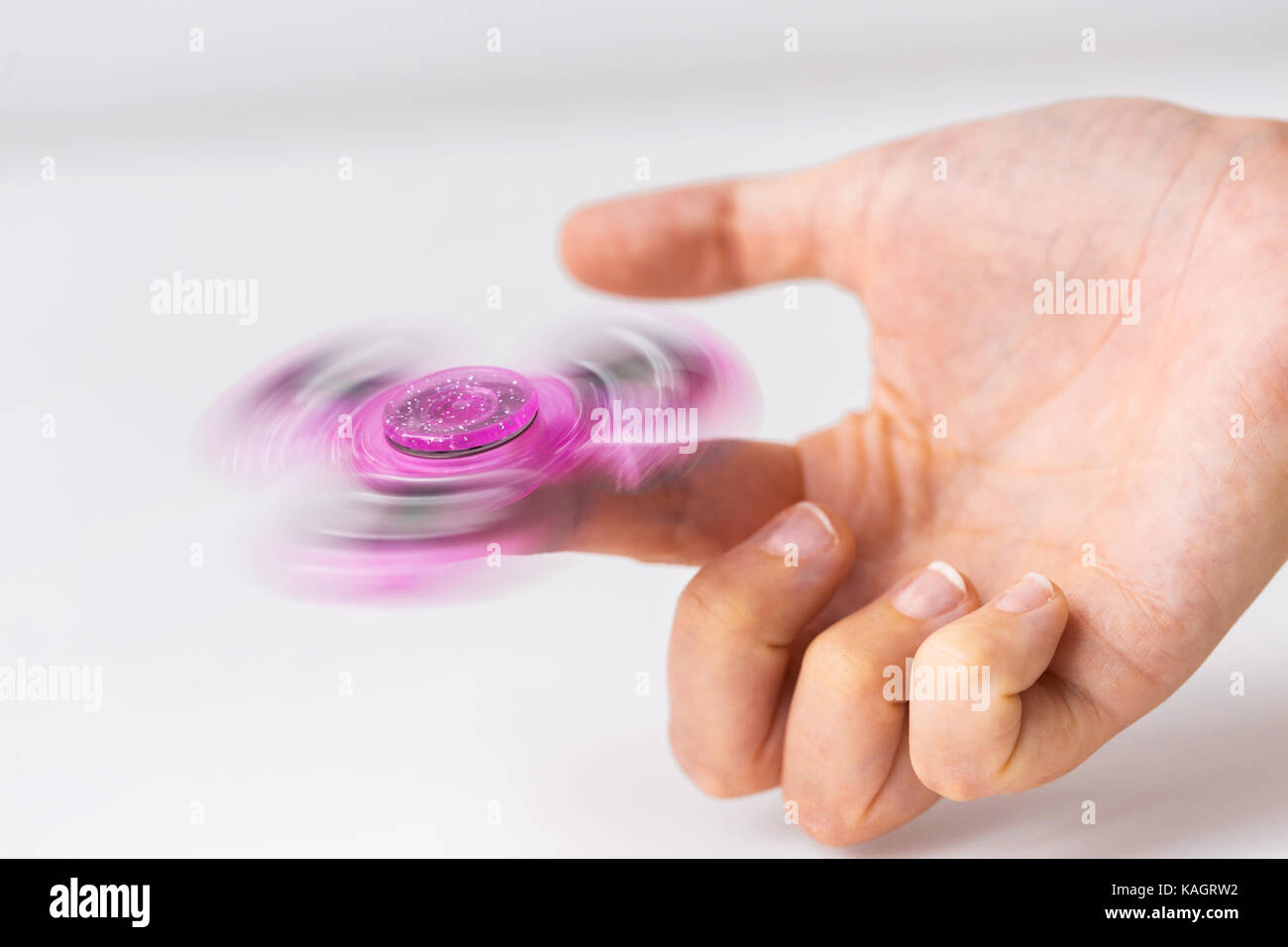 close up of hand playing with fidget spinner Stock Photo