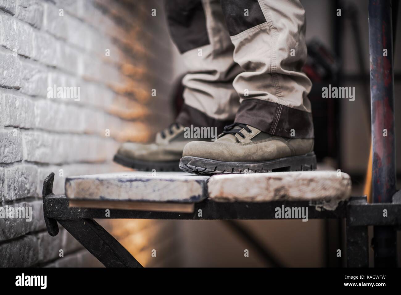 Scaffold Use in Construction Industry Concept Photo. Men Staying on Wood Planks Part of the