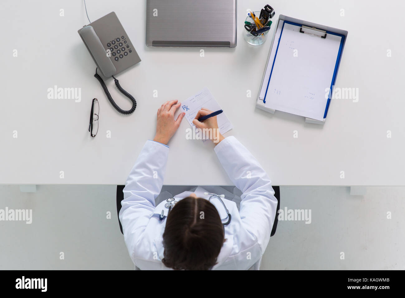 doctor writing prescription at table Stock Photo - Alamy