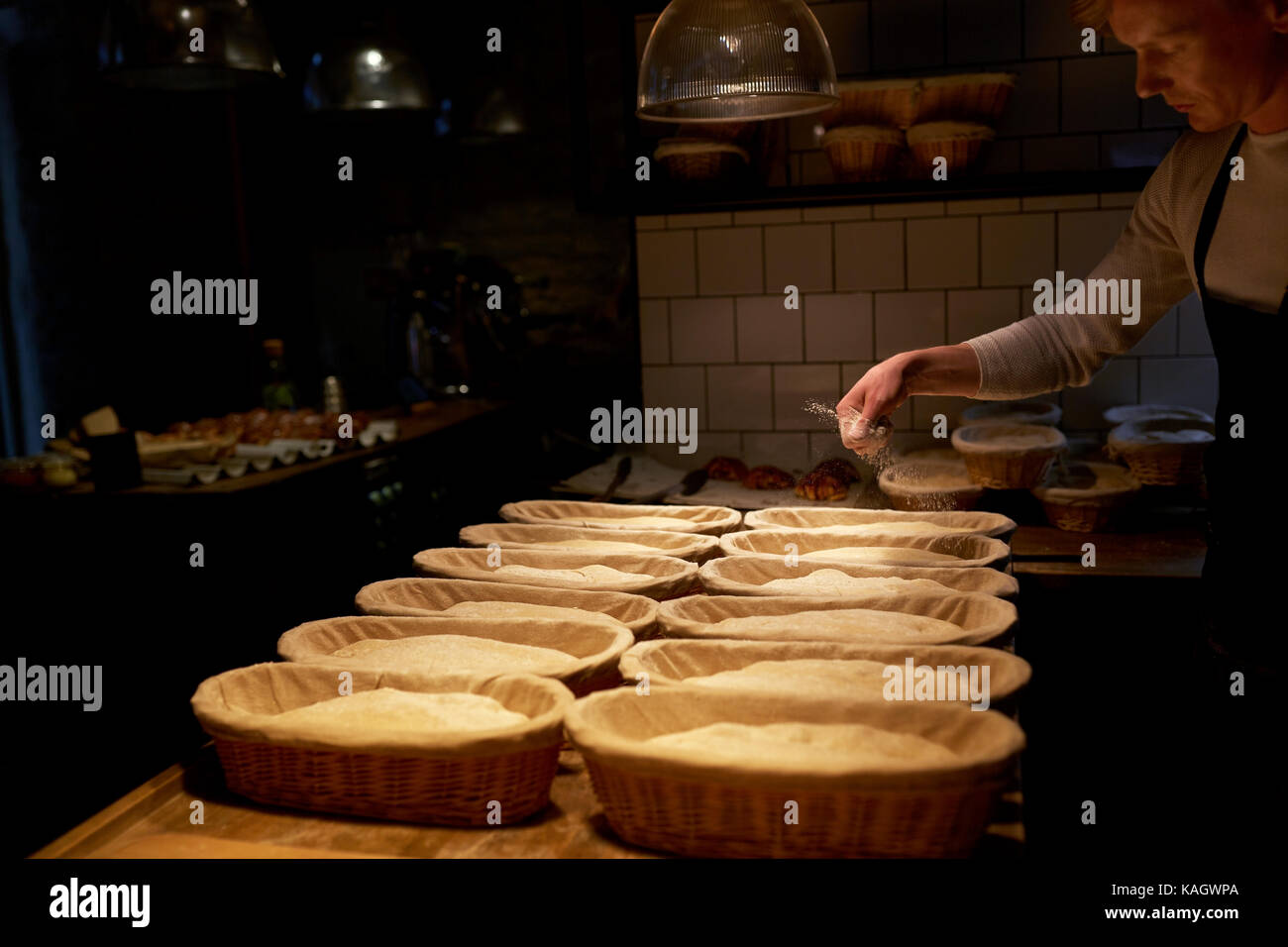 baker with baskets for dough rising at bakery Stock Photo Alamy