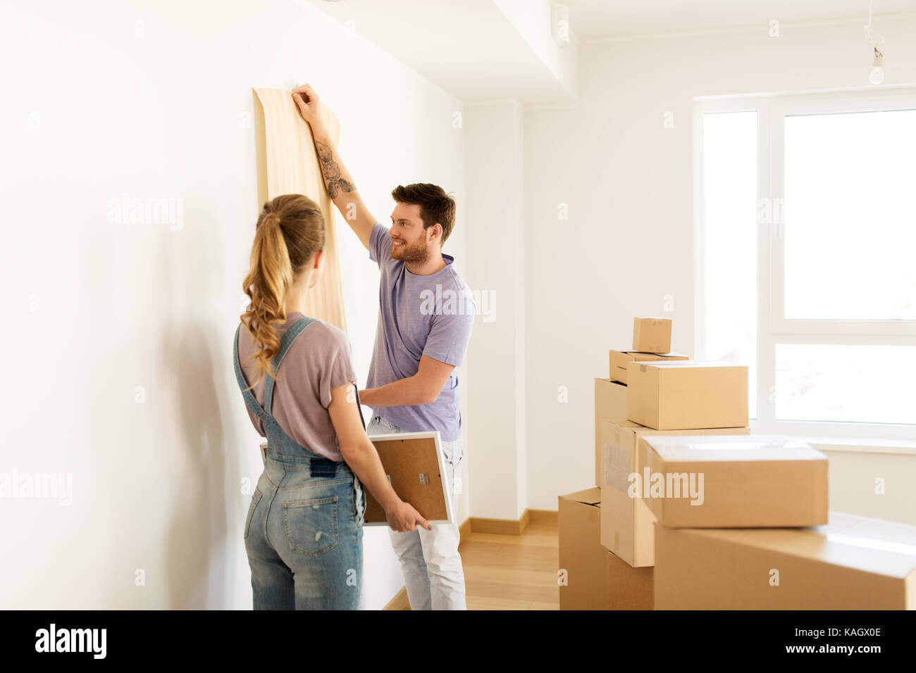 happy couple with boxes moving to new home Stock Photo - Alamy