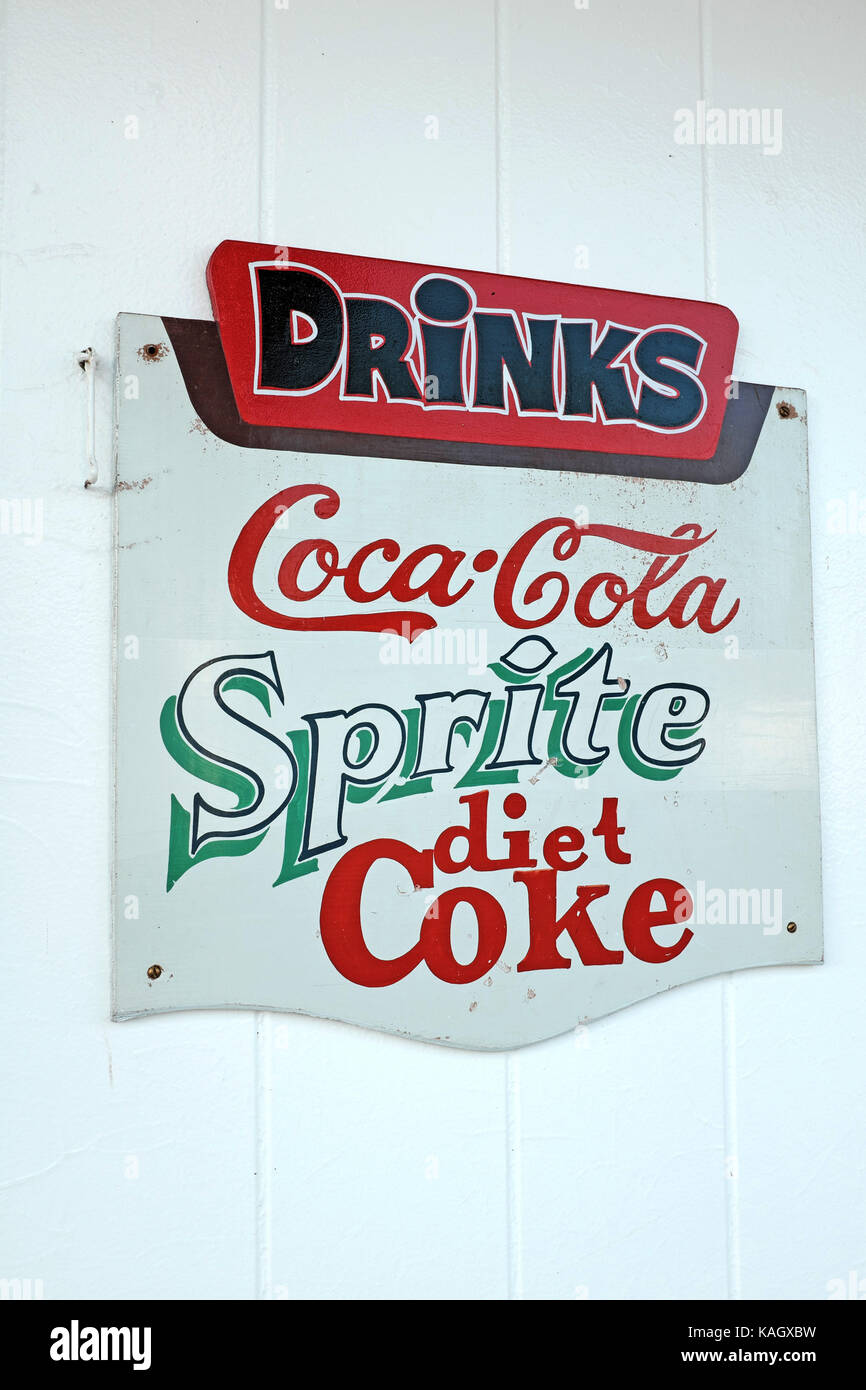Old-school soda sign hanging on a wall advertising Coca-Cola, Sprite, and Diet Coke. Stock Photo