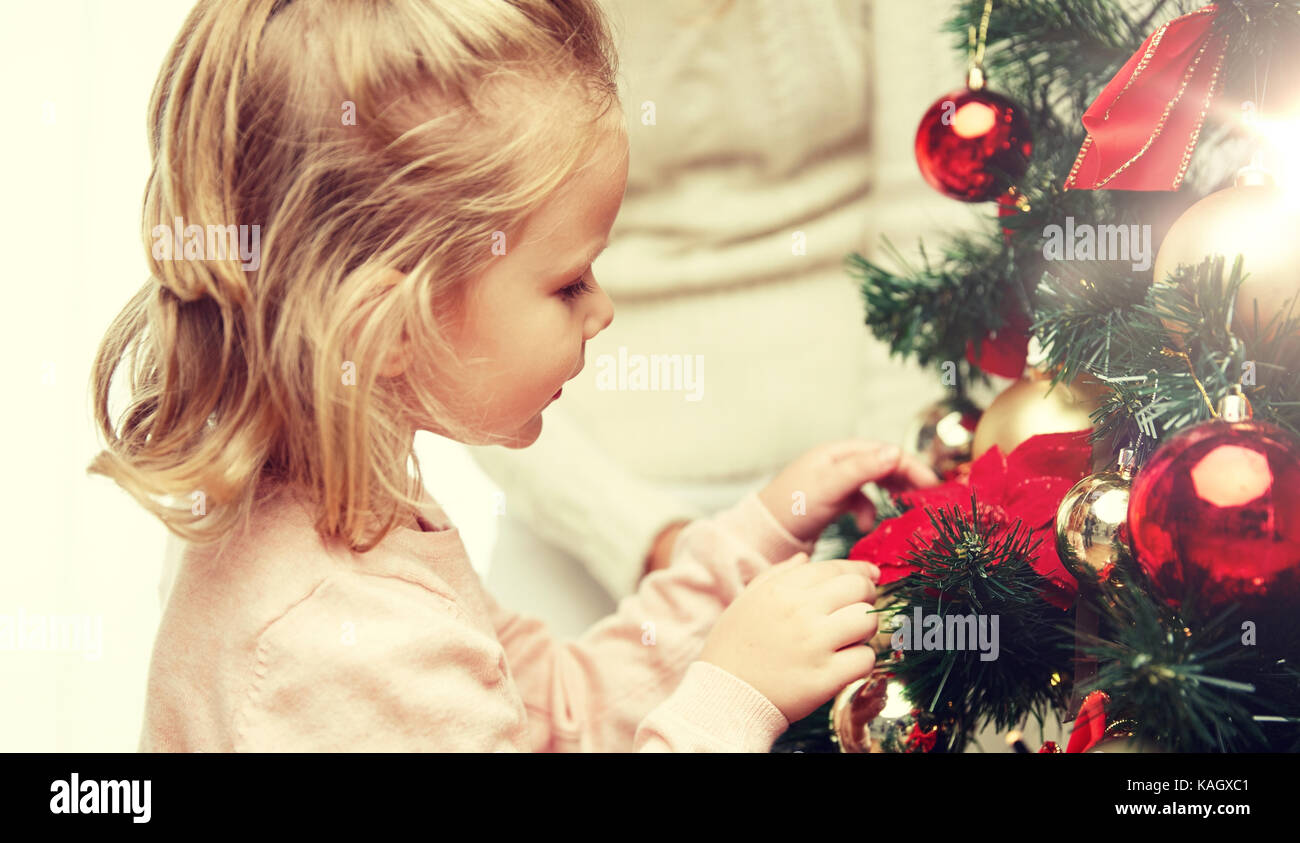 little girl decorating christmas tree at home Stock Photo - Alamy