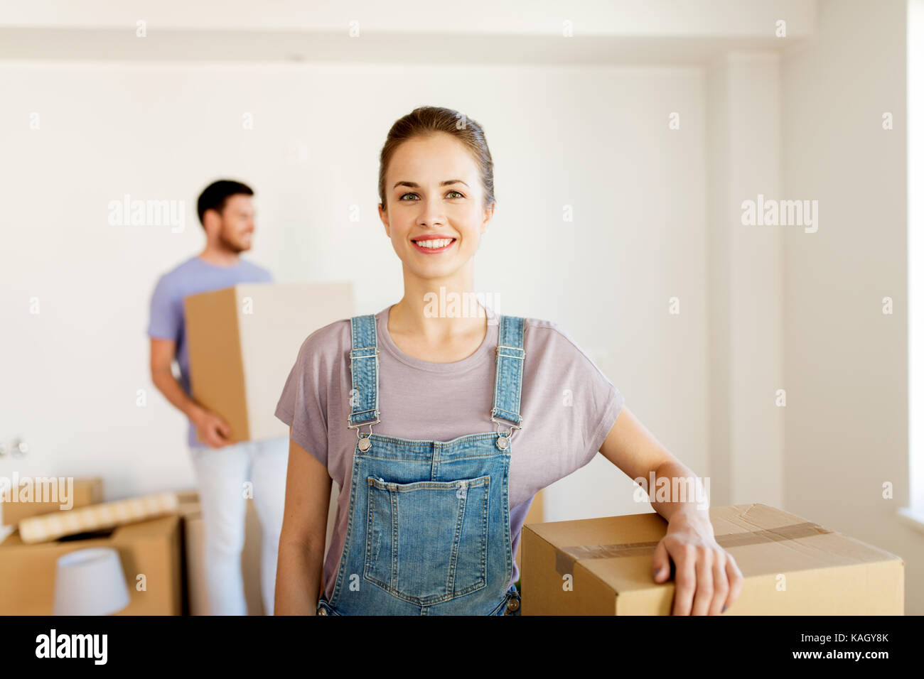 happy couple with boxes moving to new home Stock Photo - Alamy