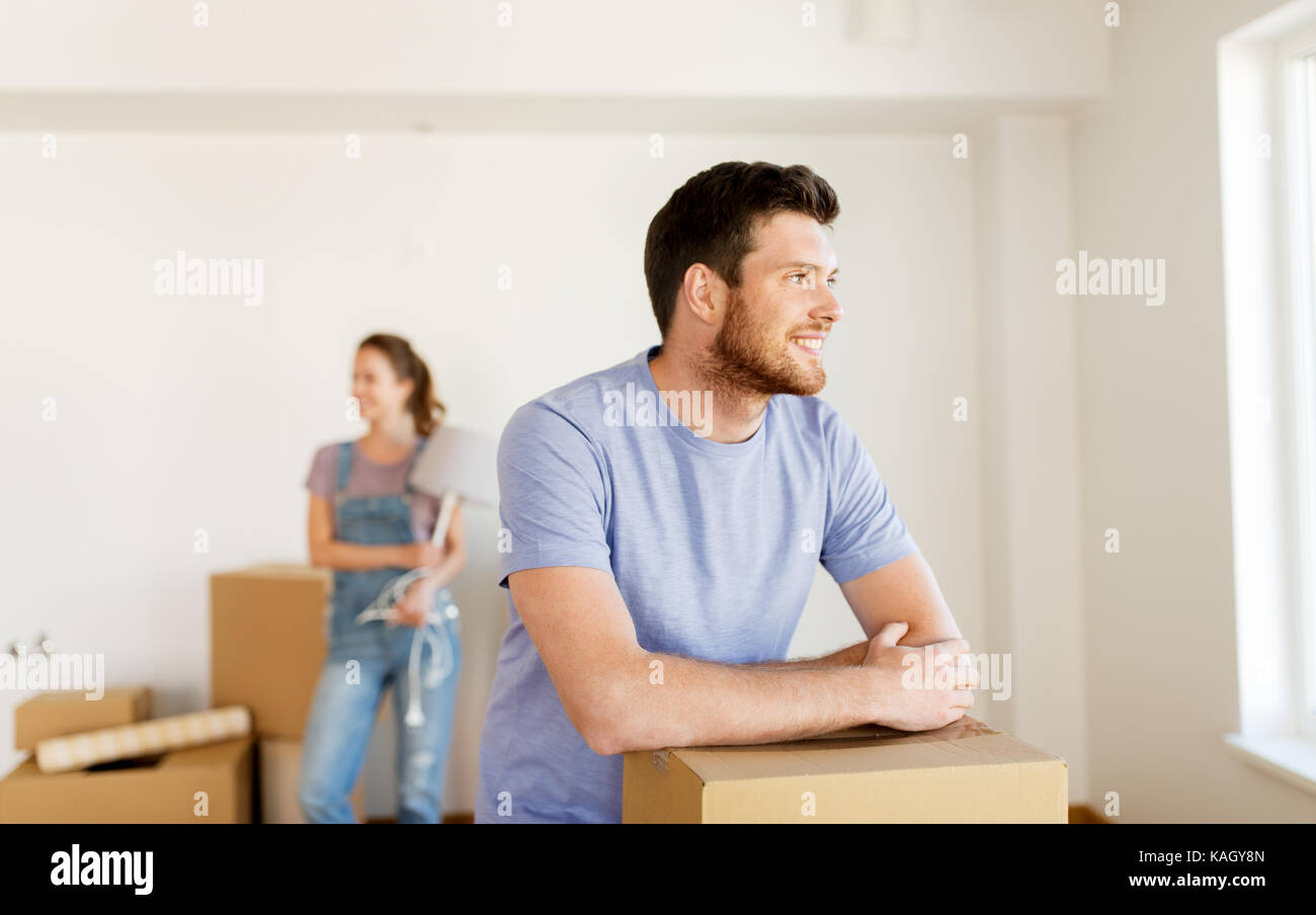 happy couple with boxes moving to new home Stock Photo - Alamy