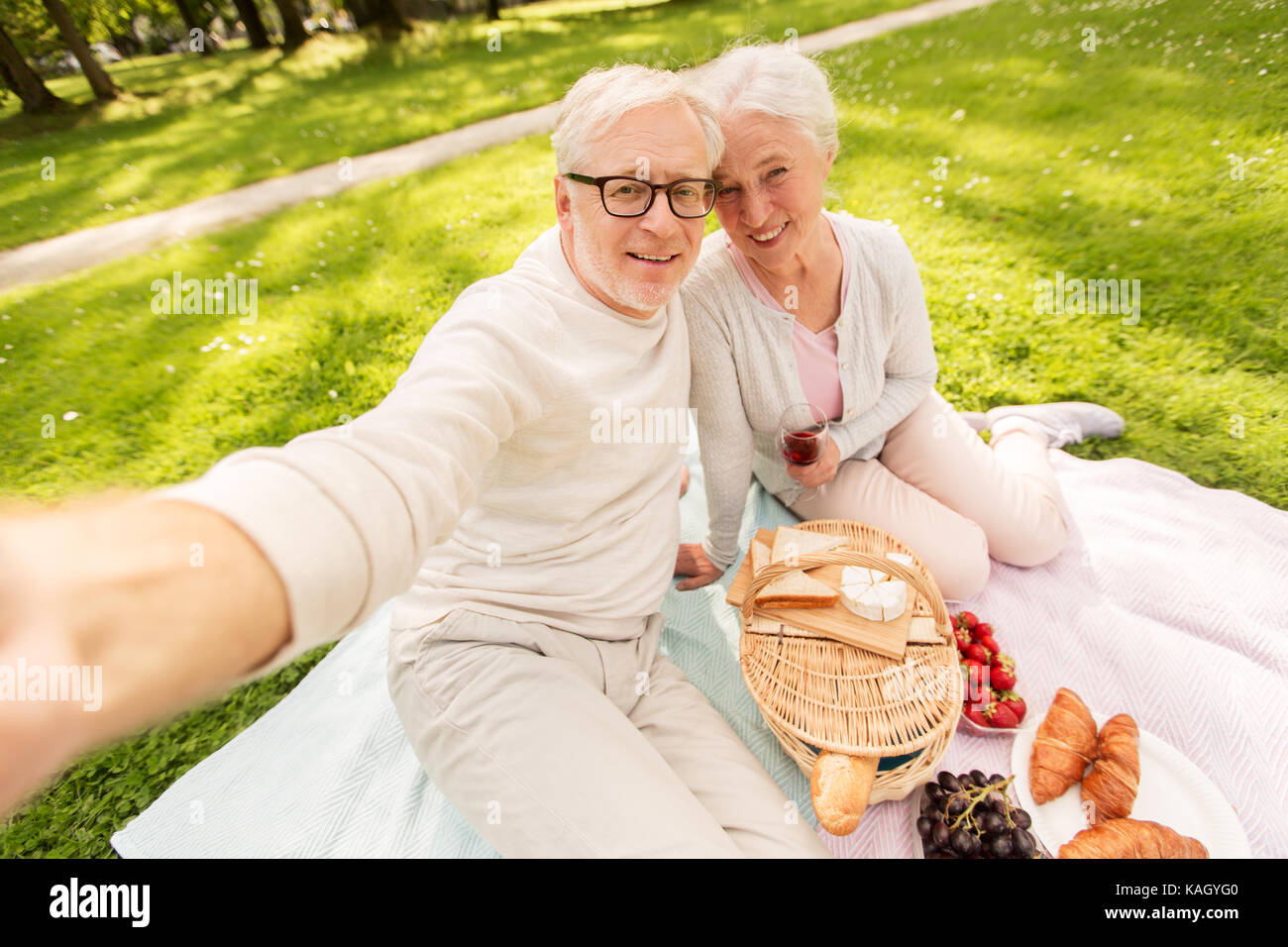 senior couple taking selfie at picnic in park Stock Photo - Alamy