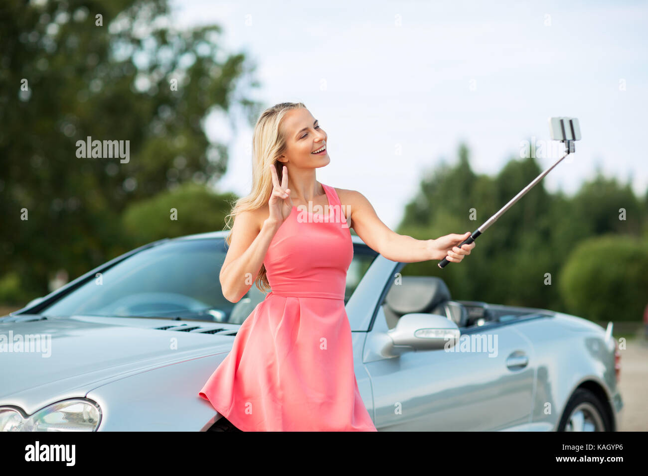 woman taking picture by selfie stick at car Stock Photo Alamy