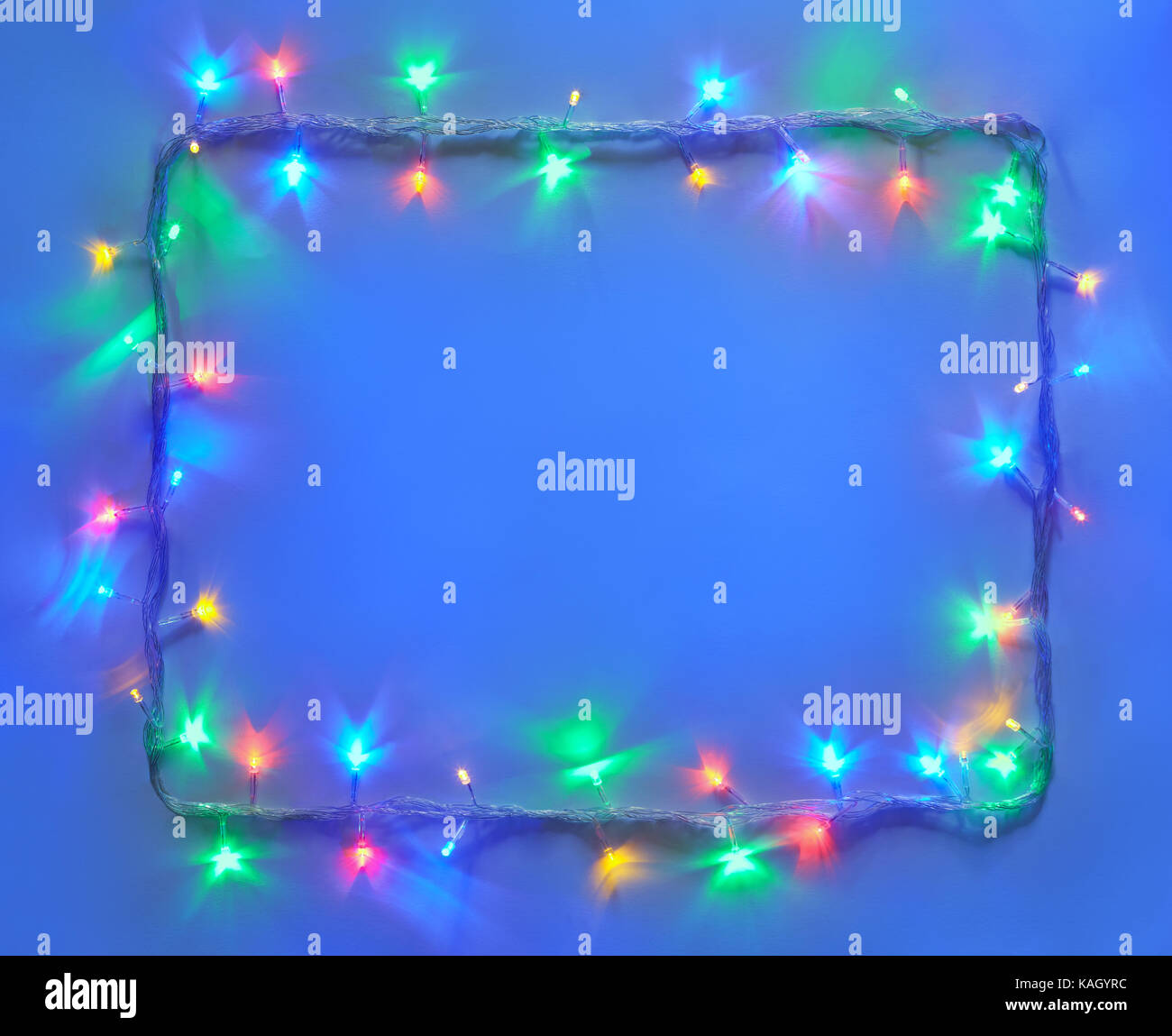 Christmas lights frame on blue background with copy space. Decorative ...