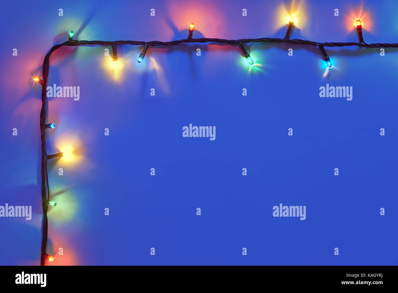 Christmas lights frame on dark blue background with copy space