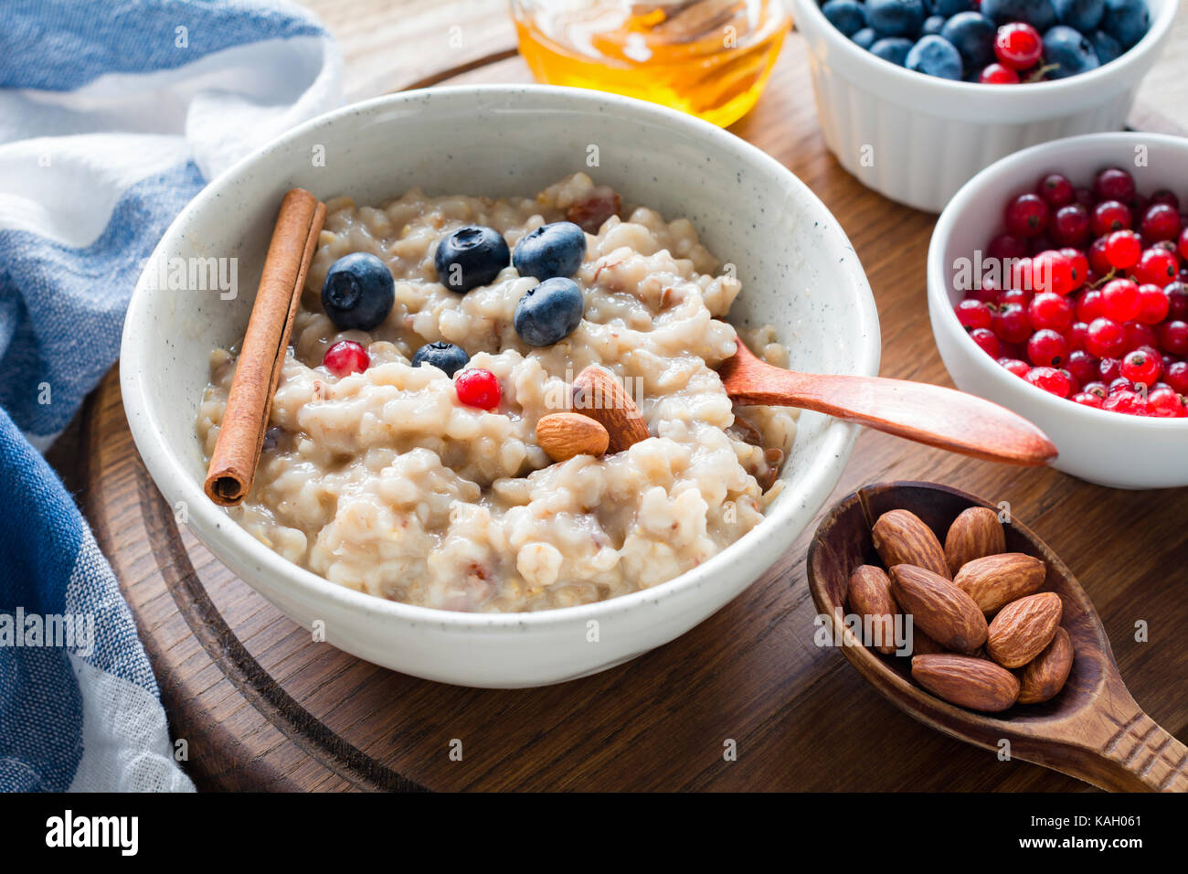 Oatmeal porridge with blueberries, almonds and currants in bowl. Healthy breakfast, dieting, balanced meal concept Stock Photo