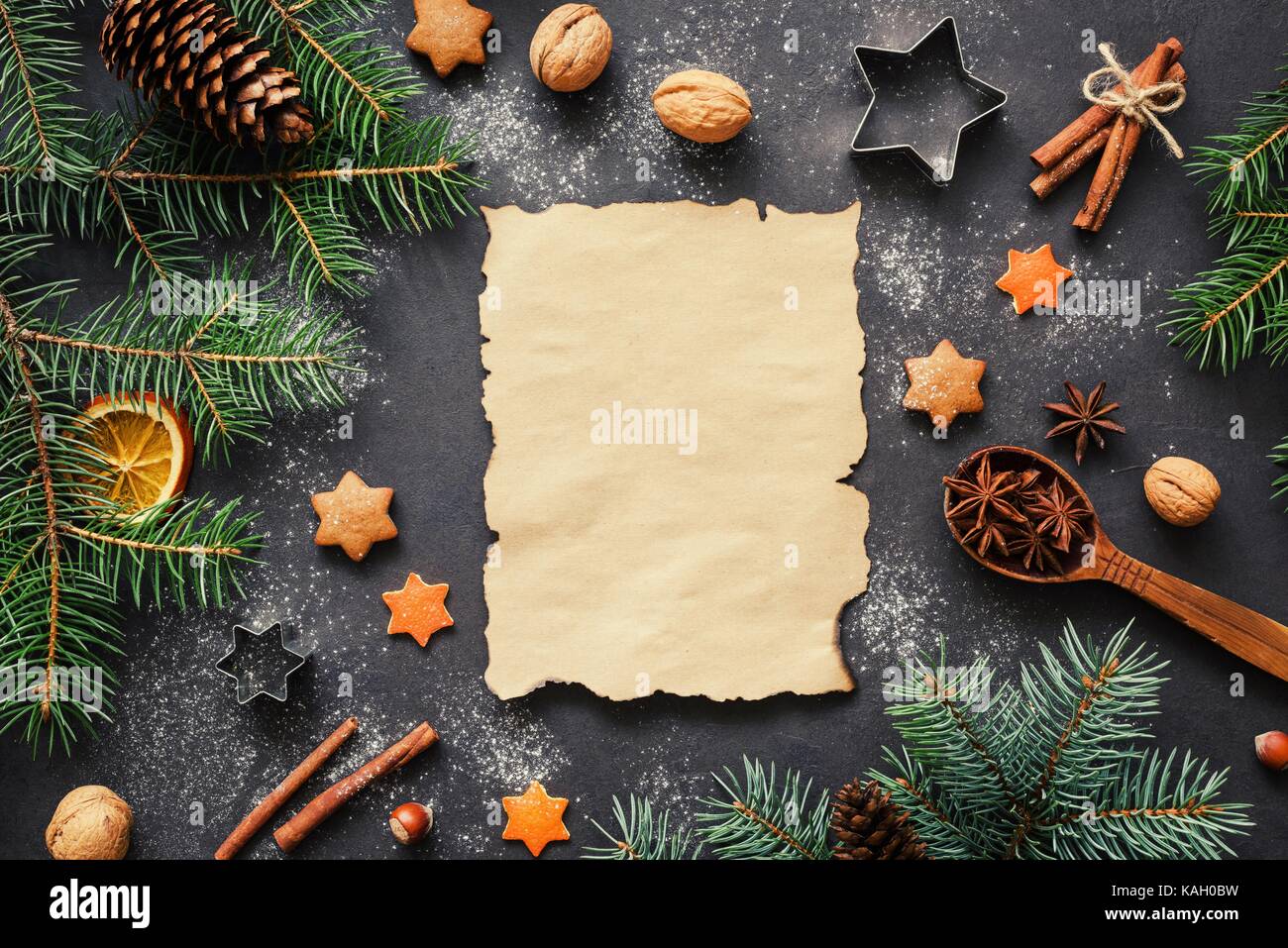 Santa wish list or Christmas letter background concept: holiday decorations, fir tree, spices, stars and cookie cutters with blank paper for text. Stock Photo