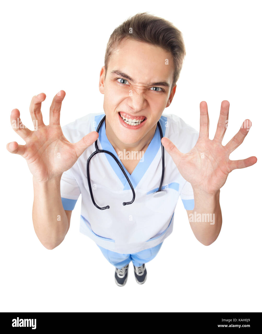 Wide angle top view of crazy angry young doctor isolated on white background Stock Photo