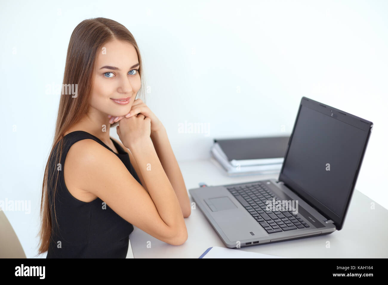 Portrait of beautiful young smiling business woman sitting at her ...