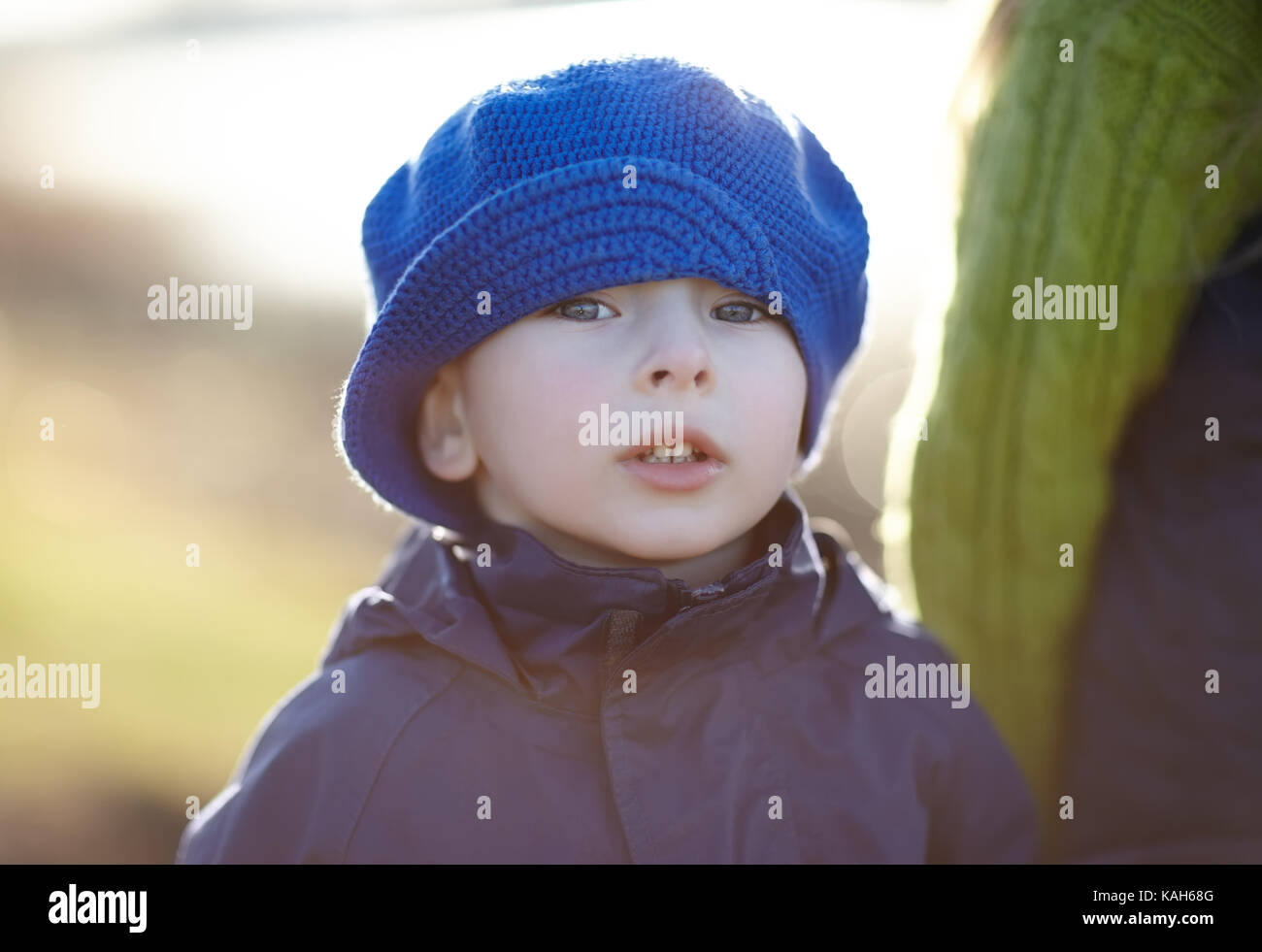 Close-up portrait of cute little boy wearing a blue hat in the autumn ...