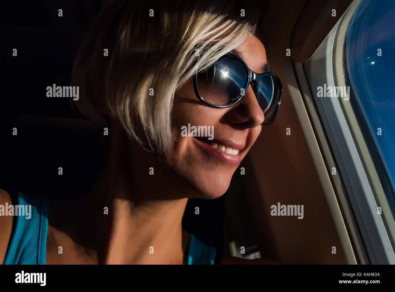 Young beautiful woman looking the sunrise through the window Stock Photo