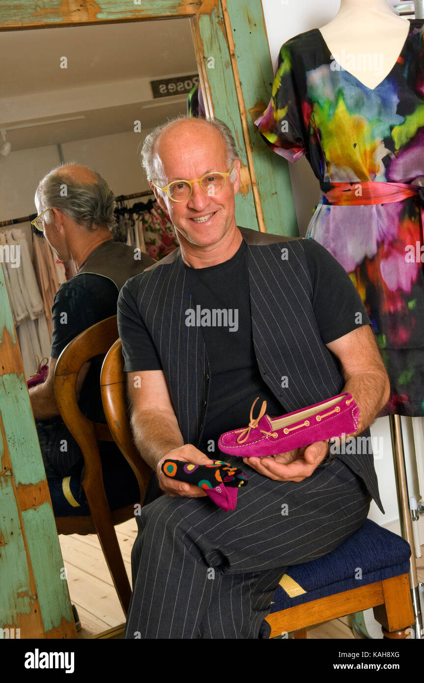 Roger Saul (holding his first Mulberry creation, a briefcase), founder