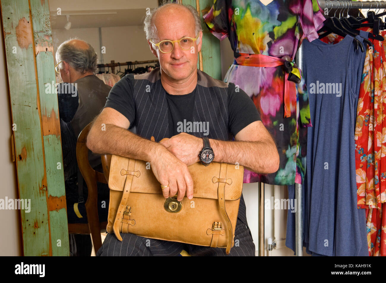 Roger Saul (holding his first Mulberry creation, a briefcase), founder