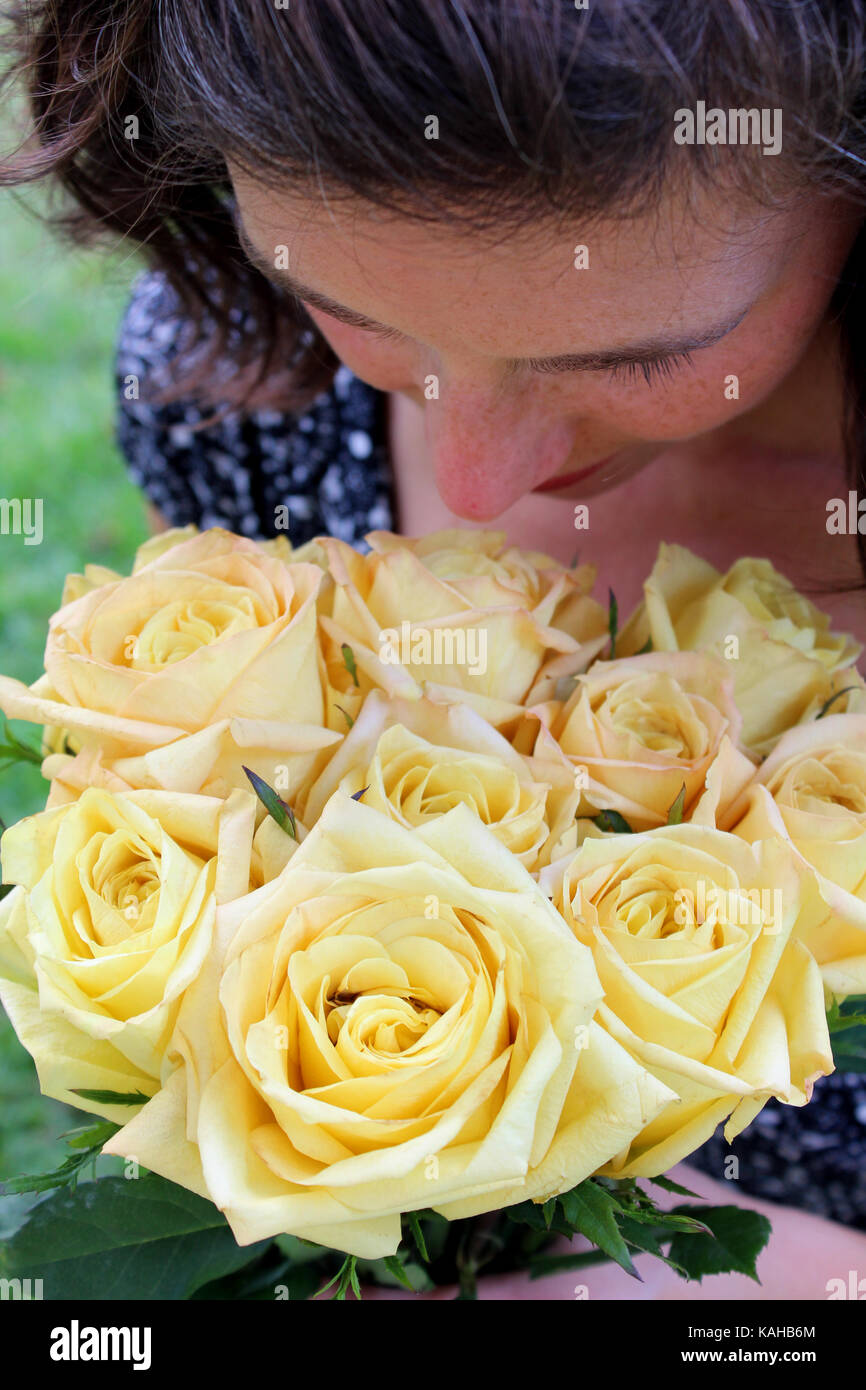 woman smells yellow roses Stock Photo Alamy