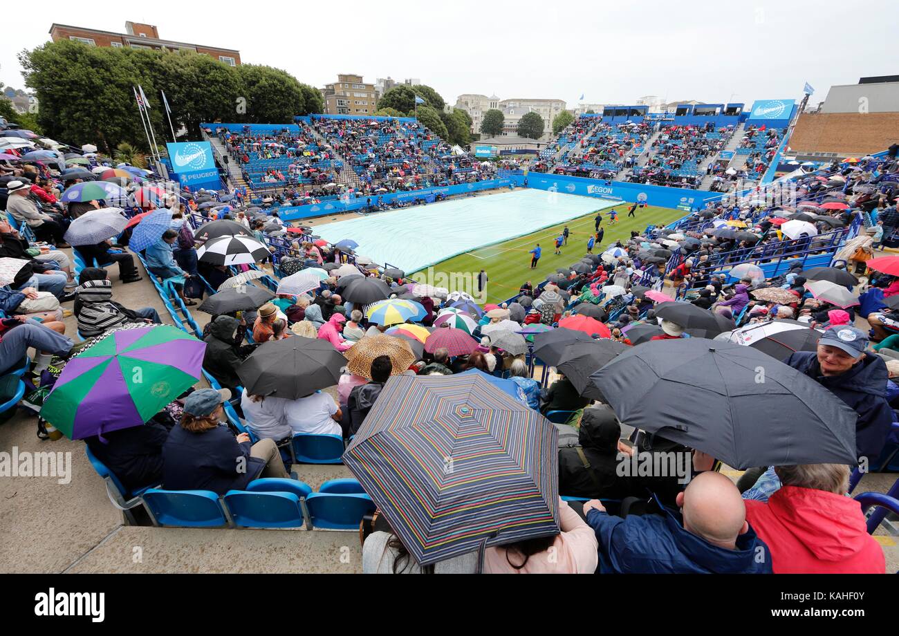 Tennis fans on Court 1 shelter under Umbrellas on day five of the Aegon International at Devonshire Park, Eastbourne. 27 Jun 2017 Stock Photo