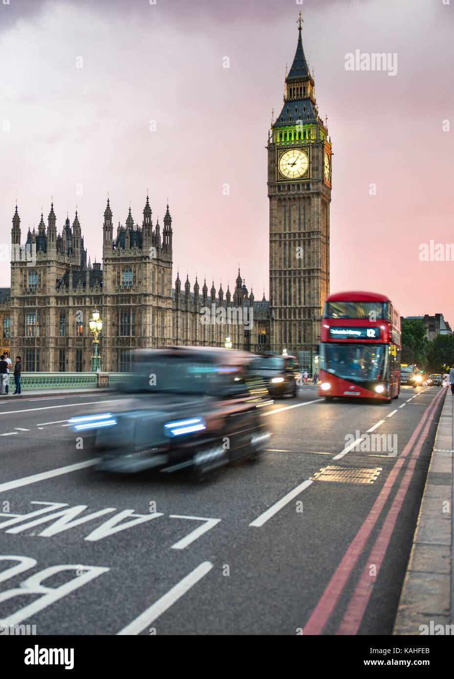 Taxi and red double-decker bus on the Westminster Bridge, Big Ben and Westminster Palace, motion blur, sunset, London, England Stock Photo