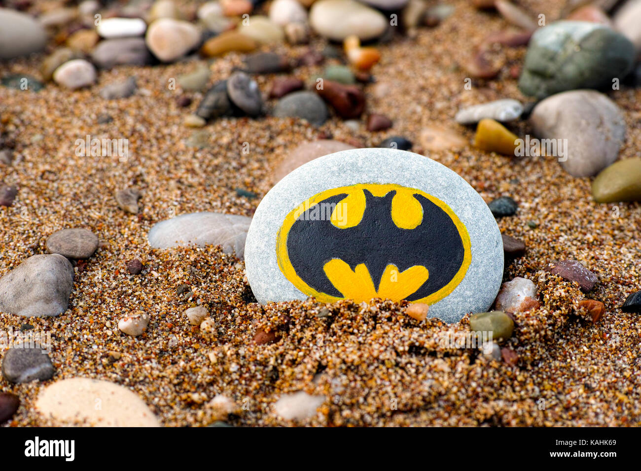 Paphos, Cyprus - November 22, 2016 Pebble with painted sign Batman on beach with sand and pebbles. Stock Photo