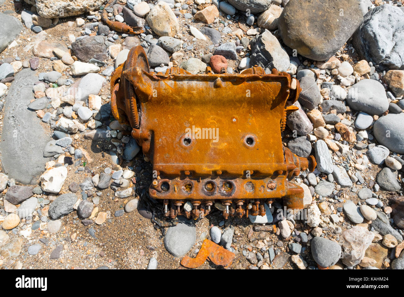 A rusty car engine on the beach at Lyme Regis on the Jurassic Coast, Dorset, England, UK. Stock Photo