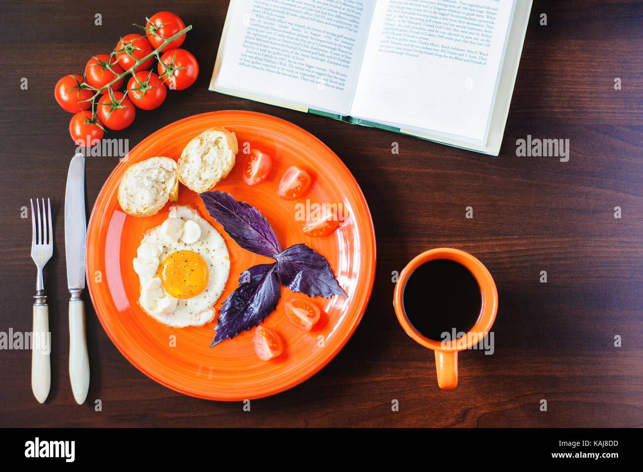 fried eggs mozzarella with basil and tomatoes on orange plate Stock