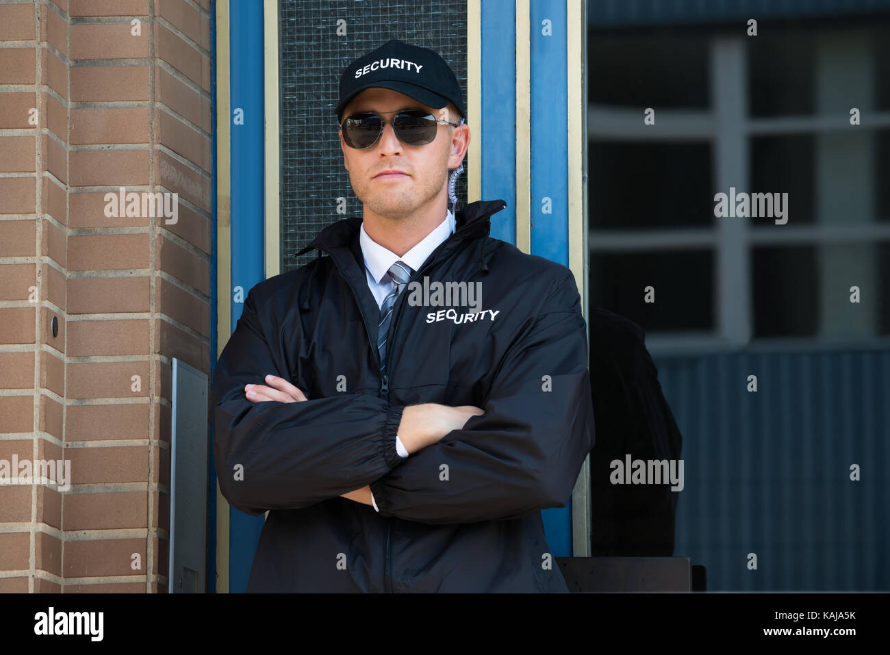 Young Confident Security Guard Standing Arm Crossed Stock Photo