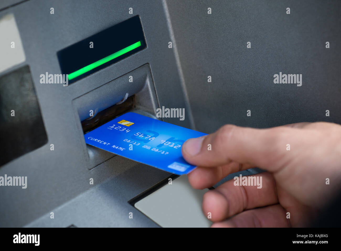 Man's Hand Using Card To Withdraw Money Stock Photo