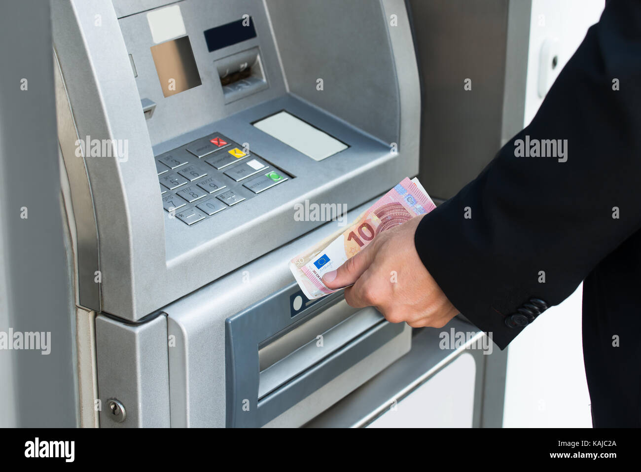 Close-up Of Person Withdrawing Money From Atm Machine Stock Photo