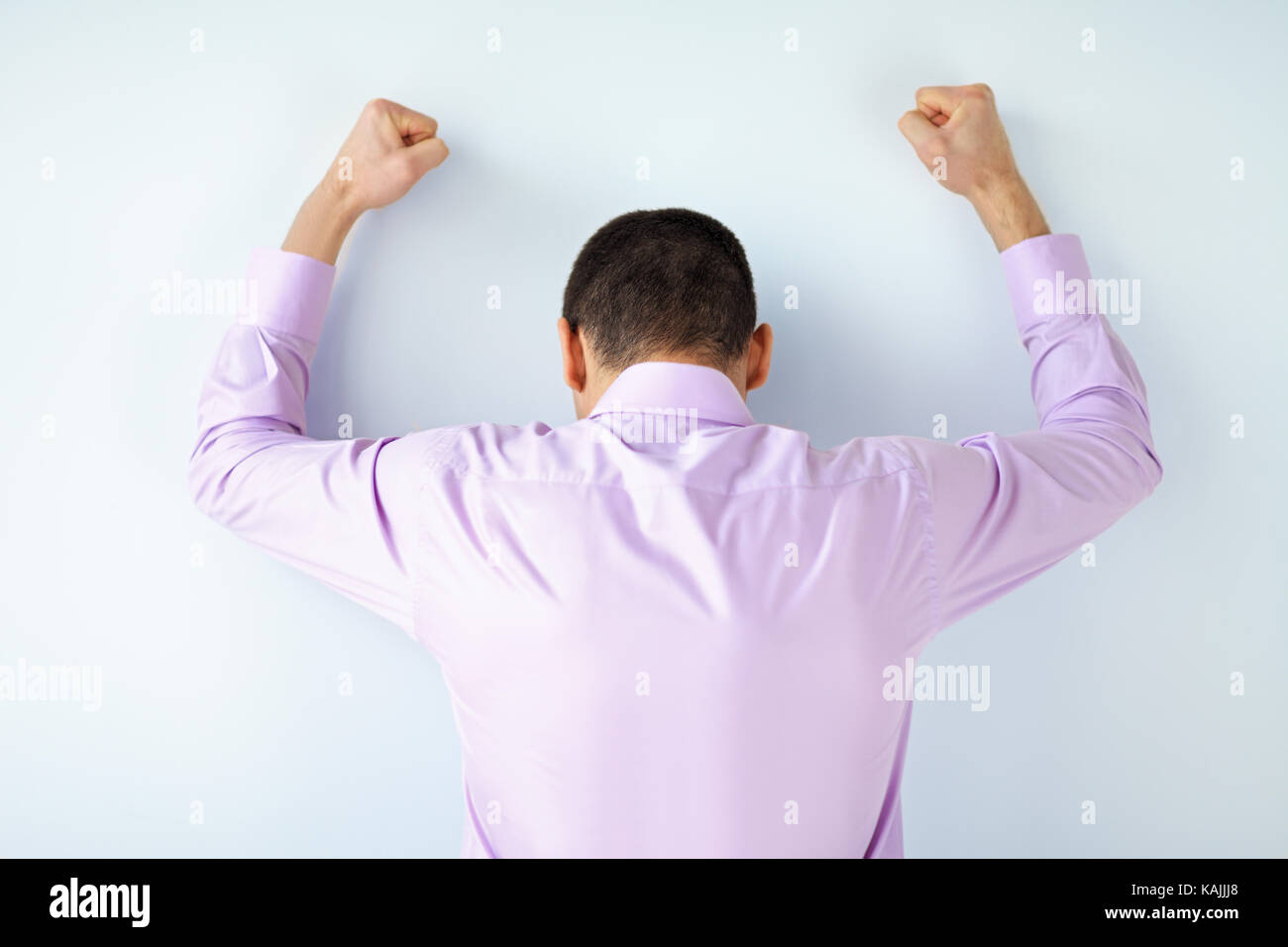 Stressed despair business man punching the wall Stock Photo
