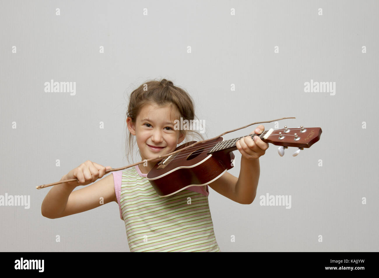 Little girl playing ukulele Stock Photo Alamy